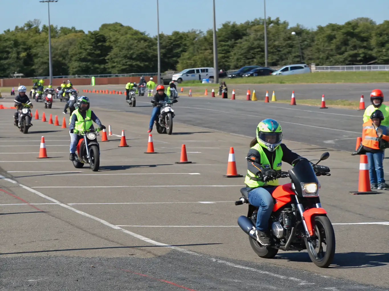 A group of motorcyclists participating in a training session on a closed circuit, focusing on improving their riding skills and safety techniques.